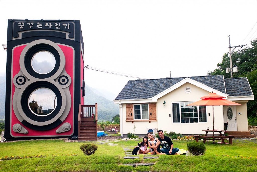 The family poses with their cafe and home just beside.